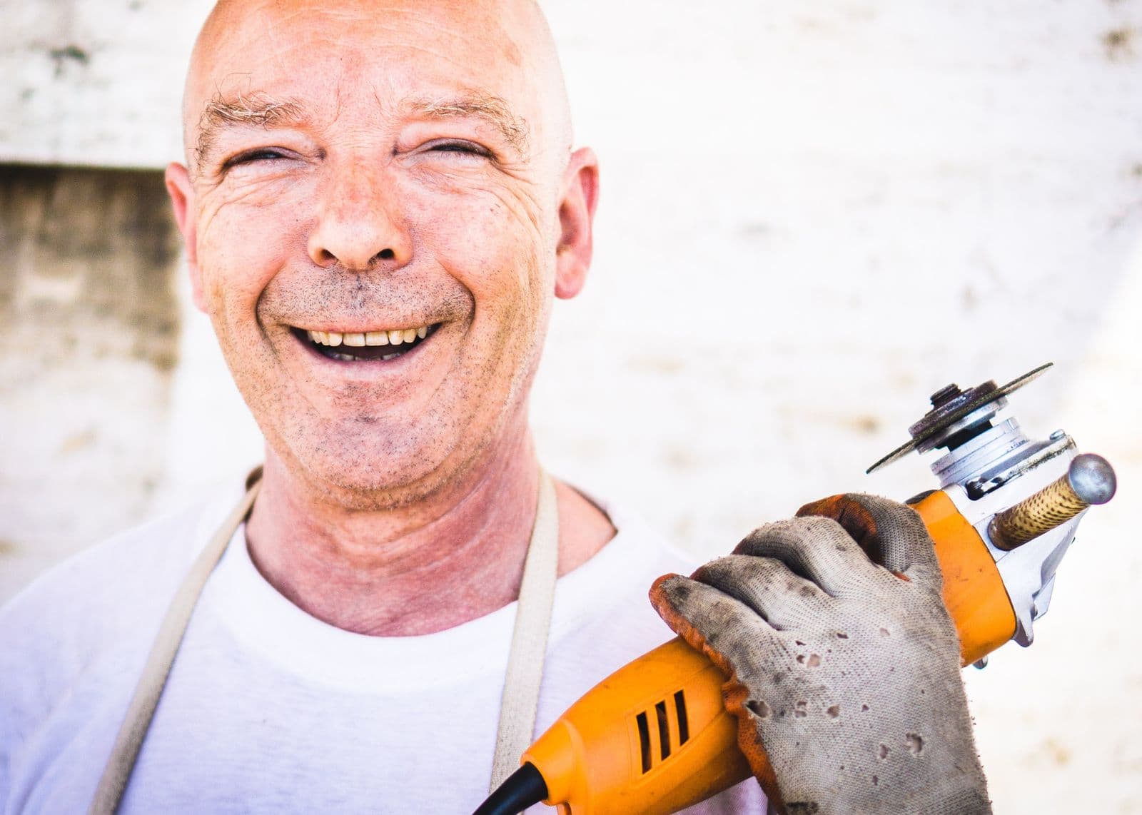 A smiling contractor holding an angle grinder